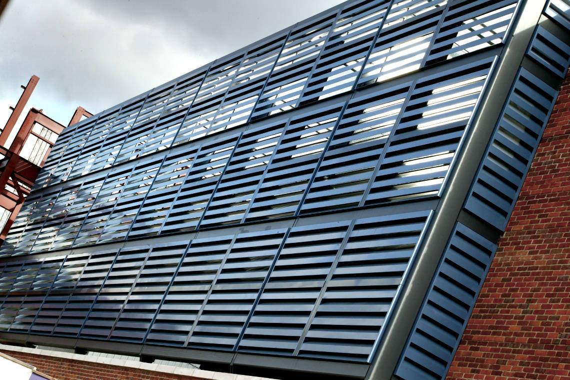 Akustisk fasadbeklädnad (Acoustic Louvers Slimshield™) som minskar buller, monterat vid ett parkeringshus.